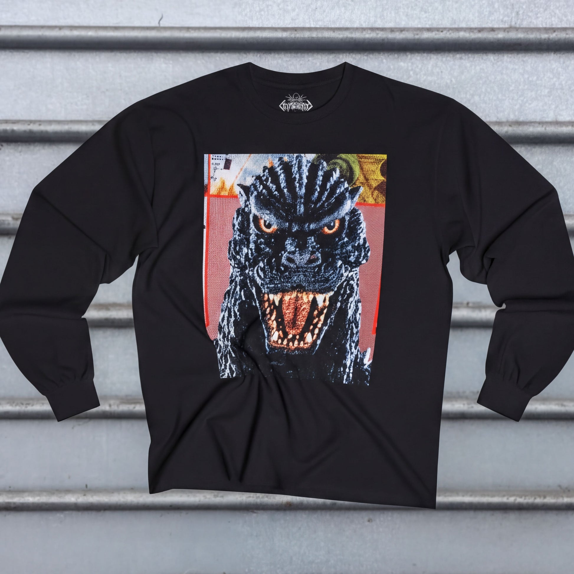 A black long-sleeved t-shirt with a graphic of a large, menacing-looking monster with a fierce expression and open mouth.